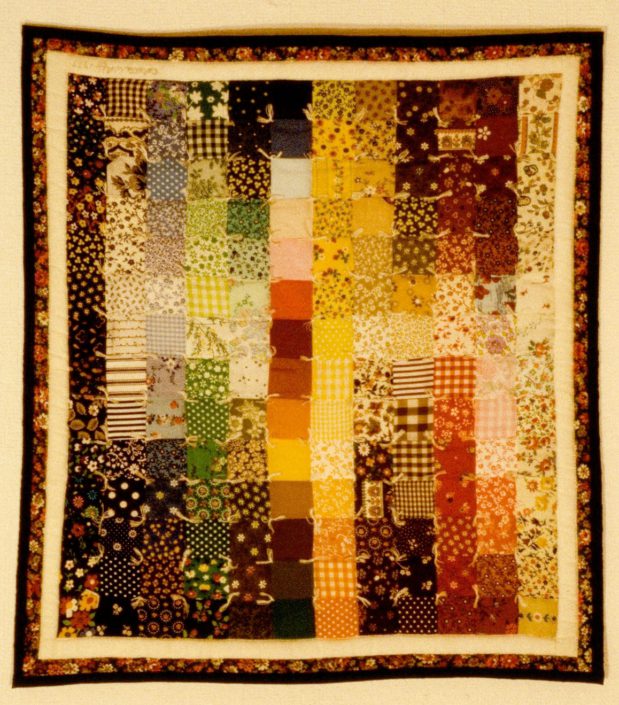 A colorful quilt with a brown border and some other colors